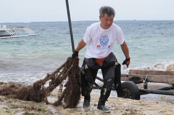 A member of the Japanese dive group tows a part of the gillnet net to the sorting area.