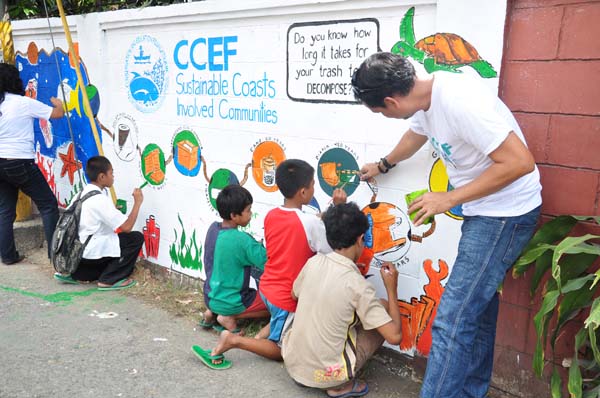 Kids join to help complete the mural